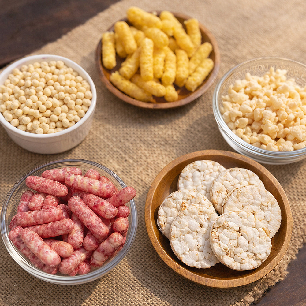 Healthy snack assortment including puffs and rice cakes by Well Krafted